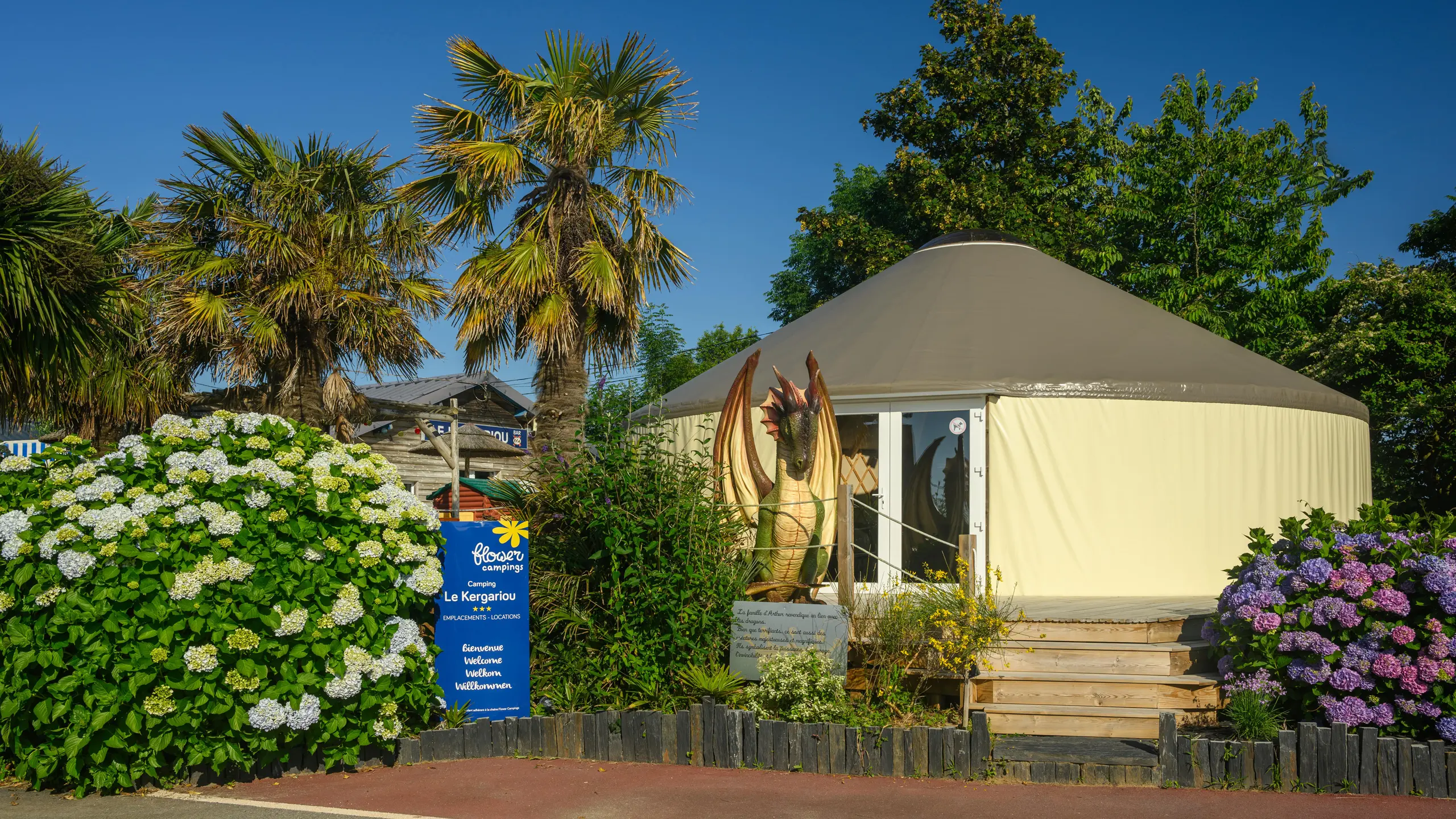 Terrasse ensoleillée avec chaises et cabane en bois.