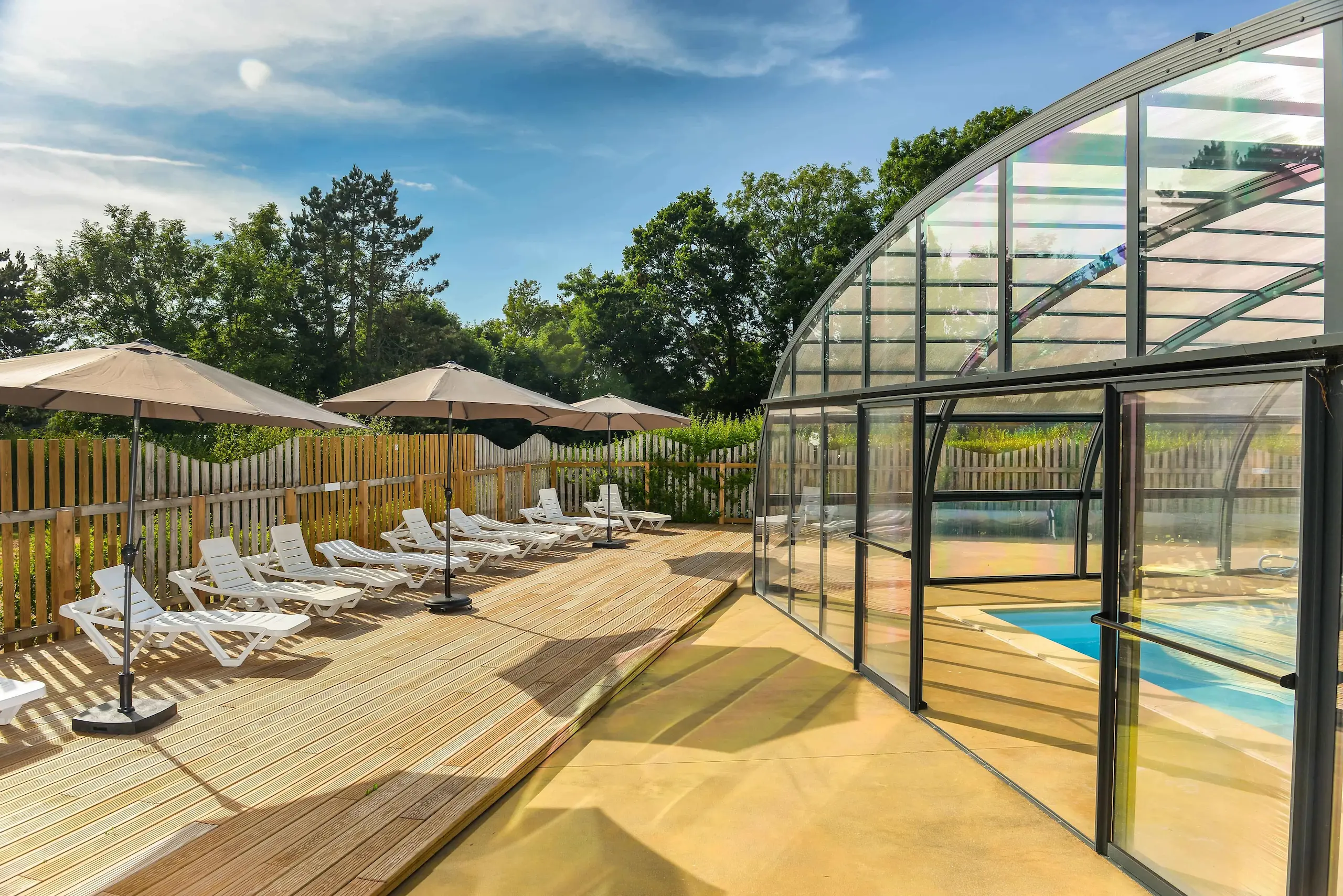 Terrasse ensoleillée avec chaises et cabane en bois.
