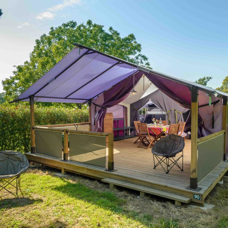 Tente lodge avec terrasse en bois, campagne.