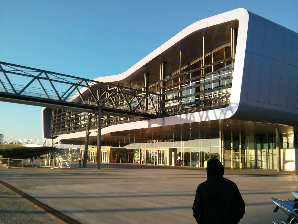 Modern gebouw met glas en loopbrug.