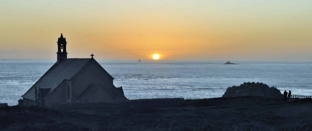 Chapelle au coucher du soleil près de la mer.