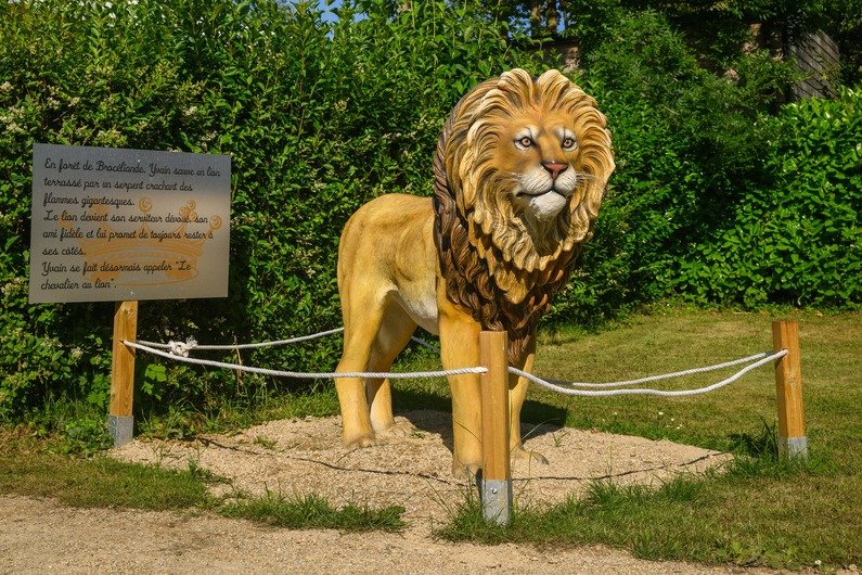 Realistisch beeld van een leeuw in een groene tuin.