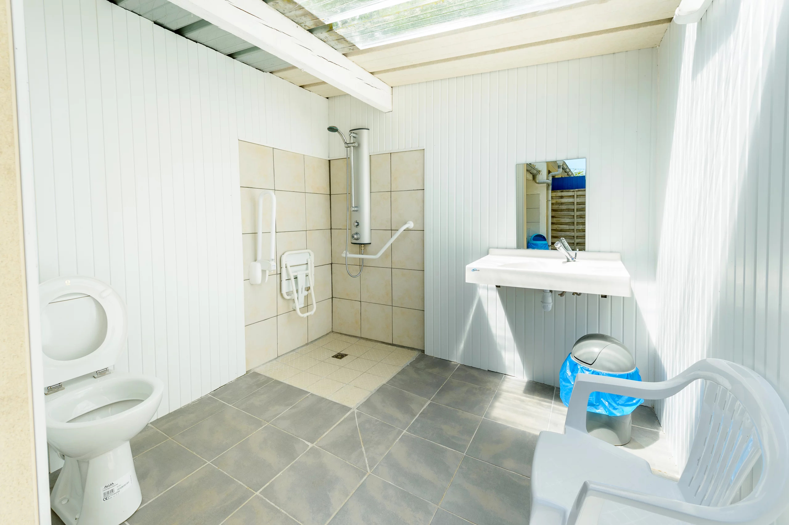 Salle de bain accessible avec douche et WC.