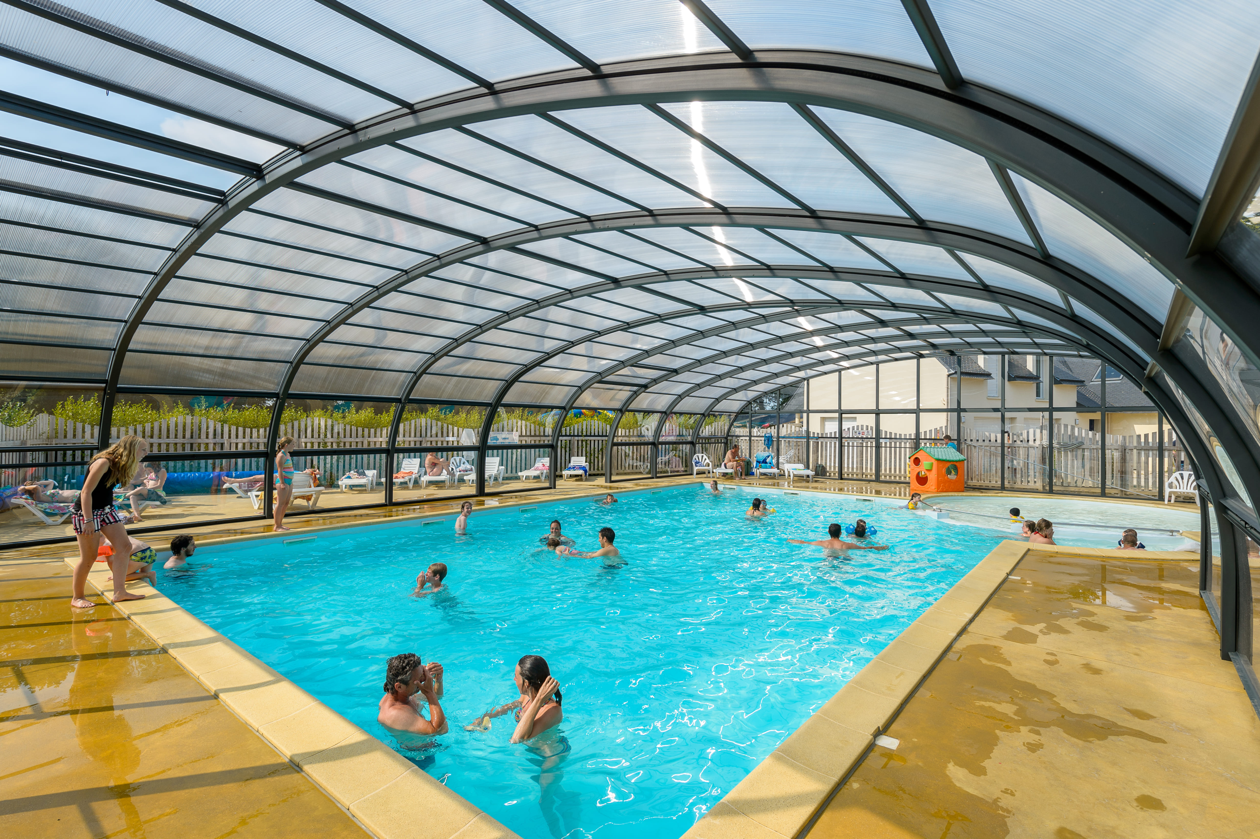 Piscine couverte avec baigneurs en vacances.