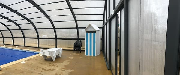Piscine couverte avec mobilier et cabine colorée
