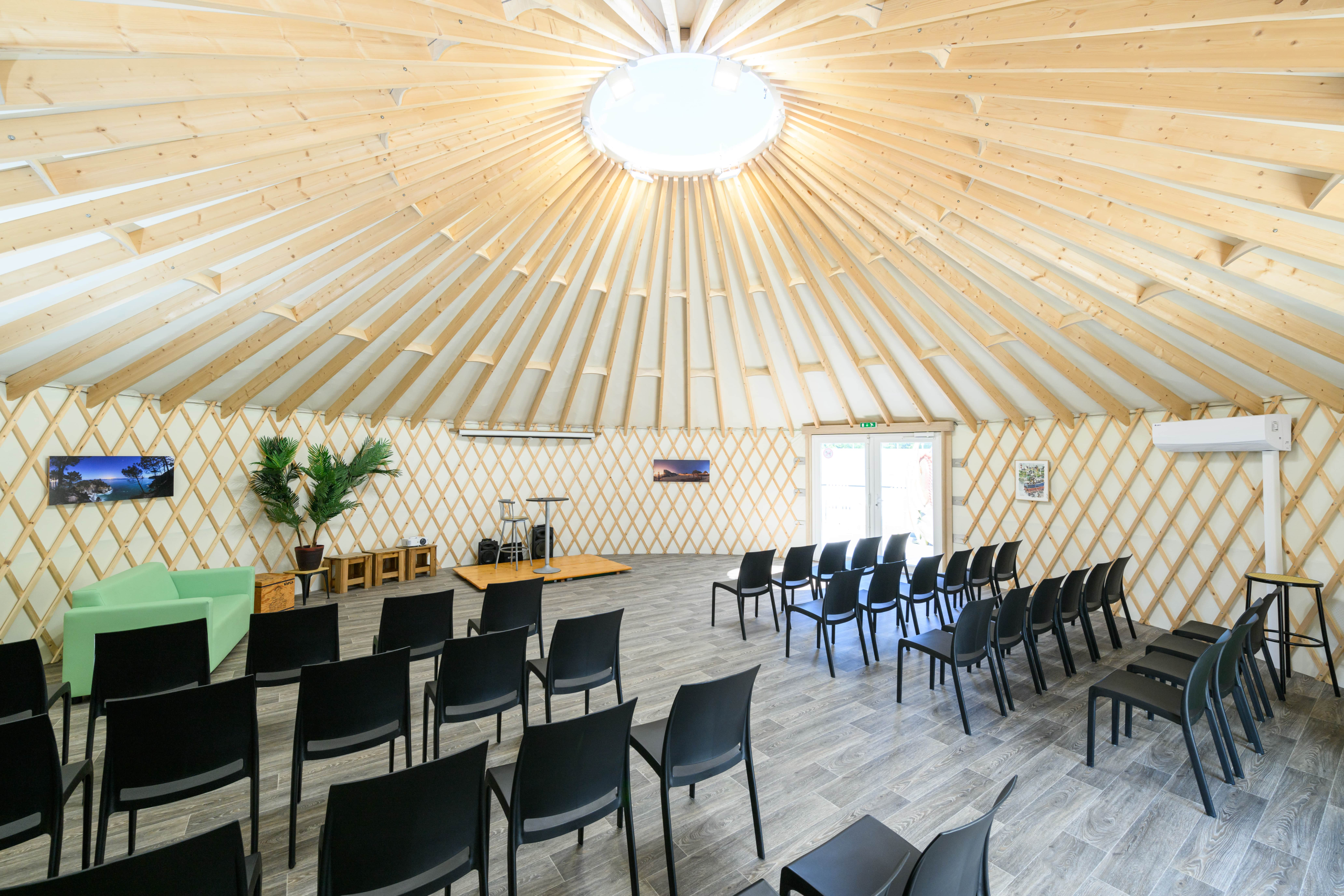 Intérieur lumineux d'une salle circulaire en bois.