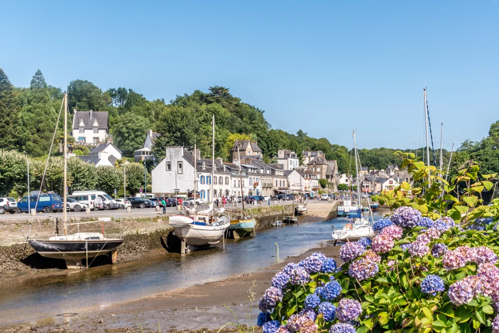 Village breton avec bateaux et hortensias en été.