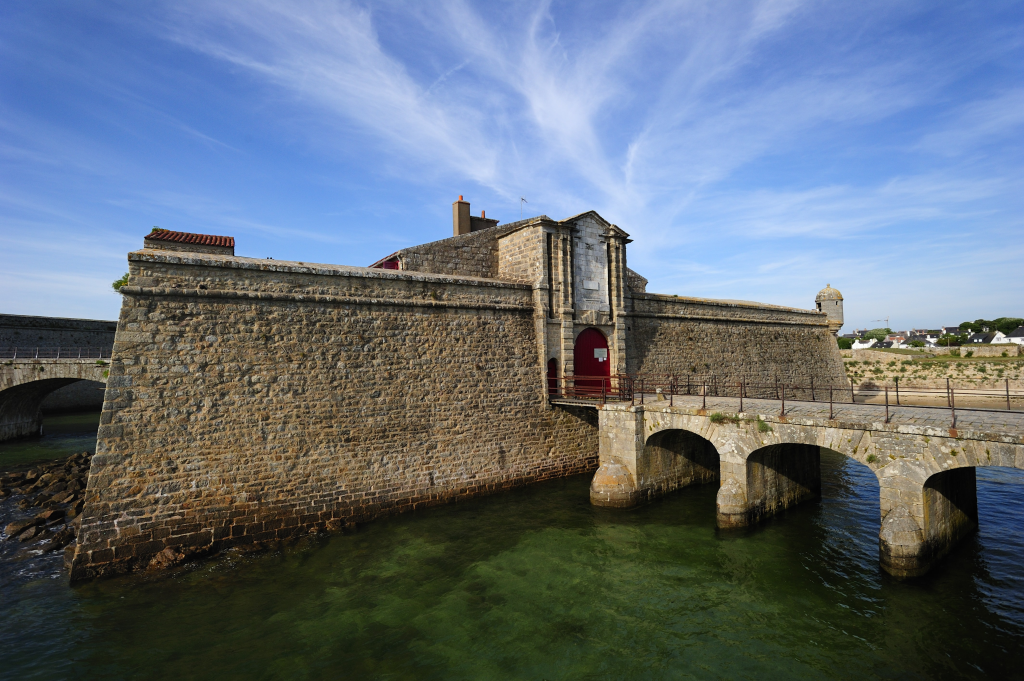 Vieux fort en bord de mer sous ciel bleu.