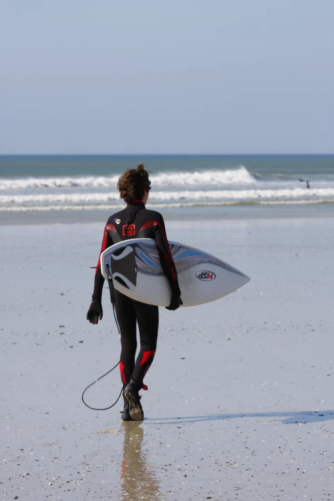 Surfer in wetsuit loopt naar de oceaan